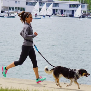 Femme qui court avec son chien et la laisse running